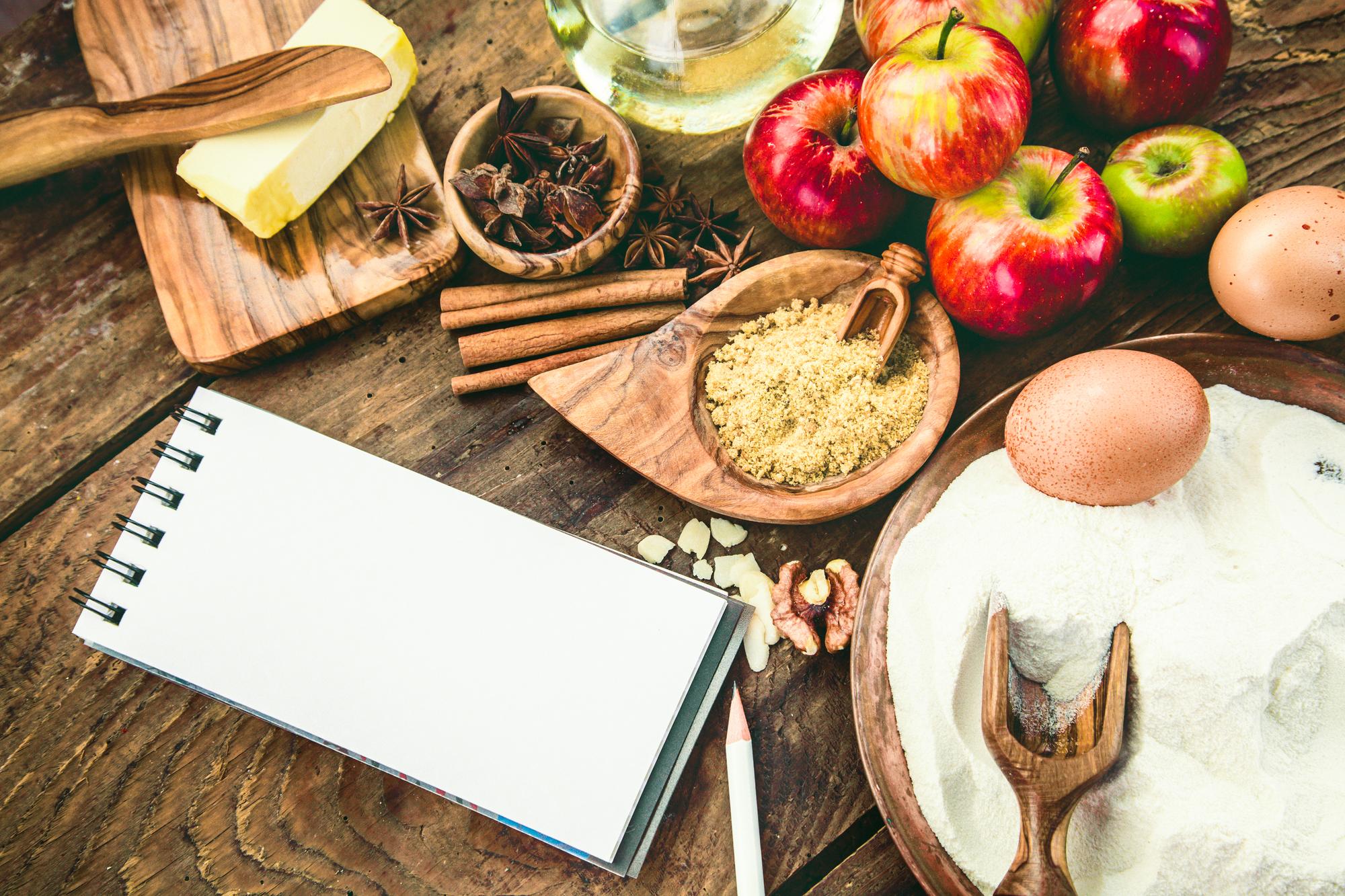 Mesa con ingredientes y cuaderno de recetas